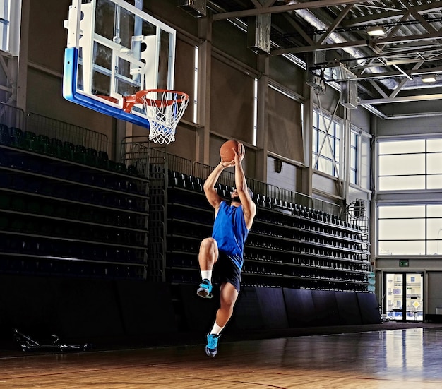 Jugador de baloncesto profesional negro en acción en un campo de baloncesto.