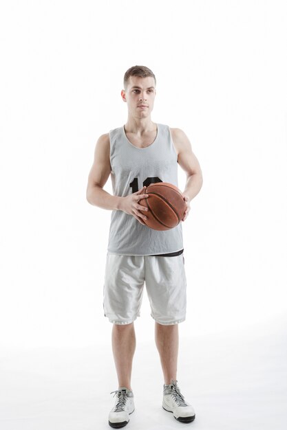 Jugador de baloncesto profesional posando con la pelota