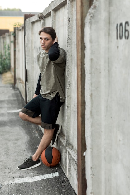Jugador de baloncesto urbano lateralmente posando
