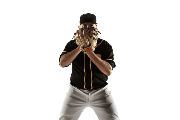 Jugador de béisbol, lanzador con uniforme negro practicando y entrenando aislado en una pared blanca. Joven deportista profesional en acción y movimiento. Estilo de vida saludable, deporte, concepto de movimiento.