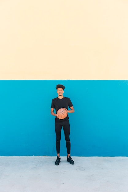 Jugador étnico con baloncesto en la calle.