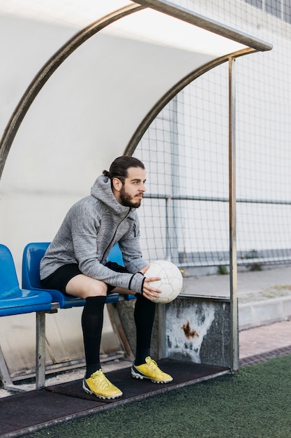 Foto gratuita jugador de fútbol en banco