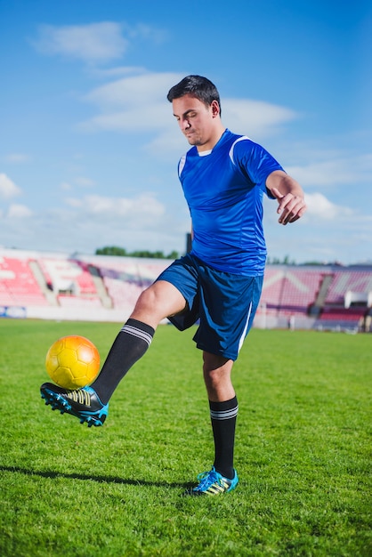 Jugador de fútbol equilibrando pelota en pie