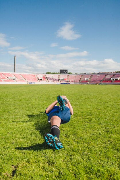 Jugador de fútbol estirando piernas