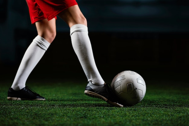 Foto gratuita jugador de fútbol femenino pateando la pelota cerca u