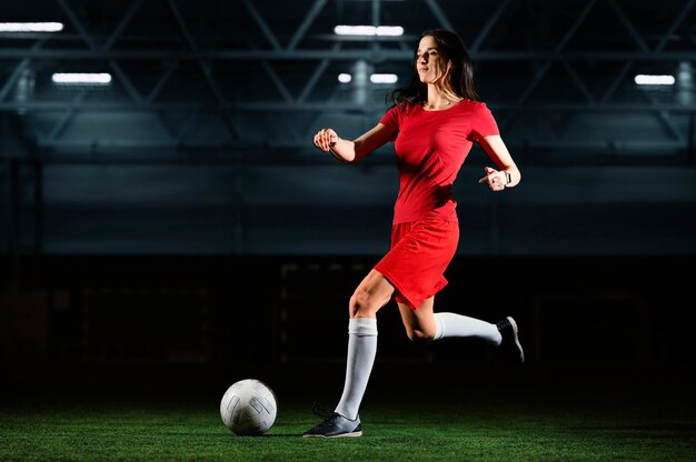 Jugador de fútbol femenino pateando la pelota