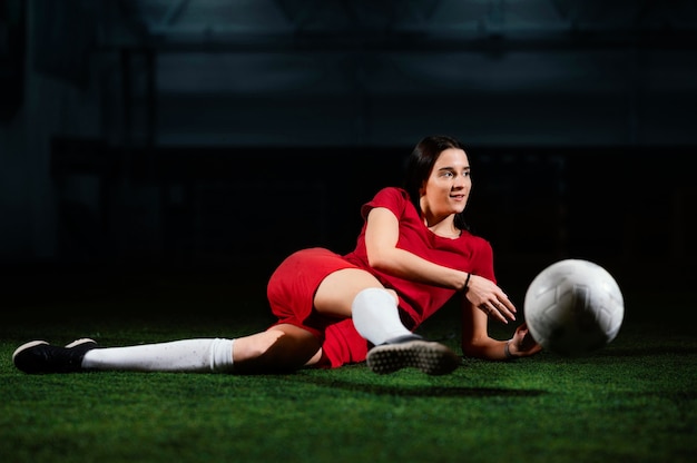 Foto gratuita jugador de fútbol femenino pateando la pelota