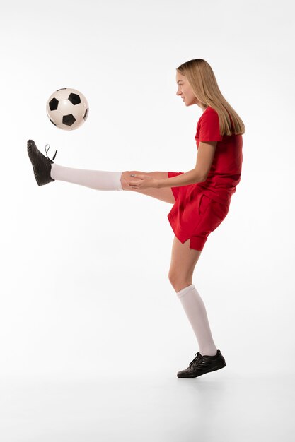 Jugador de fútbol femenino pateando la pelota