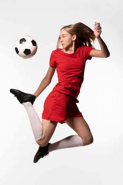 Jugador de fútbol femenino pateando la pelota