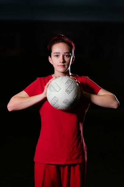 Jugador de fútbol femenino sosteniendo la bola