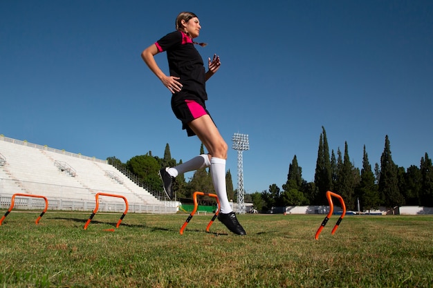 Jugador de fútbol femenino de tiro completo en el campo