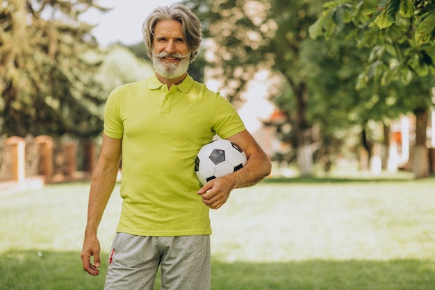 Jugador de fútbol de mediana edad con pelota de fútbol