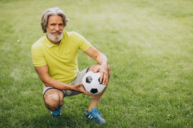 Jugador de fútbol de mediana edad con pelota de fútbol