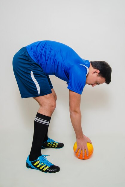 Jugador de fútbol poniendo pelota