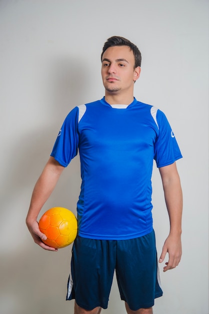 Foto gratuita jugador de fútbol posando con pelota