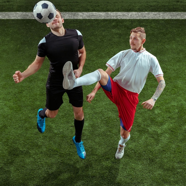 Jugador de fútbol que aborda la pelota sobre la hierba verde