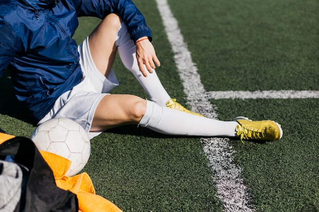 Foto gratuita jugador de fútbol sentado en campo