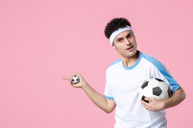 Jugador de fútbol de vista frontal en ropa deportiva con pelota