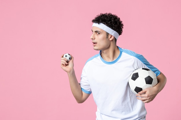 Jugador de fútbol de vista frontal en ropa deportiva con pelota
