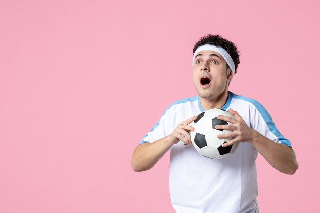 Jugador de fútbol de vista frontal en ropa deportiva con pelota