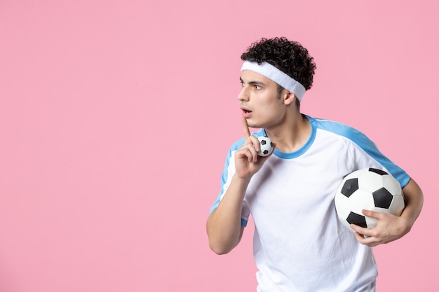 Jugador de fútbol de vista frontal en ropa deportiva con pelota