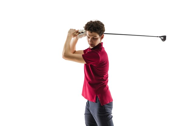 Jugador de golf en una camisa roja tomando un swing en estudio blanco