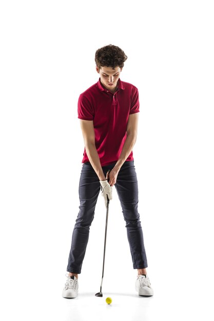 Jugador de golf en un entrenamiento de camisa roja practicando aislado sobre fondo blanco de estudio