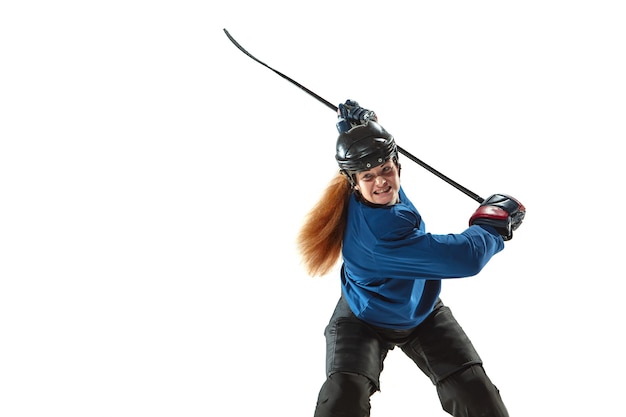 Jugador de hockey femenino joven con el palo en la cancha de hielo y pared blanca