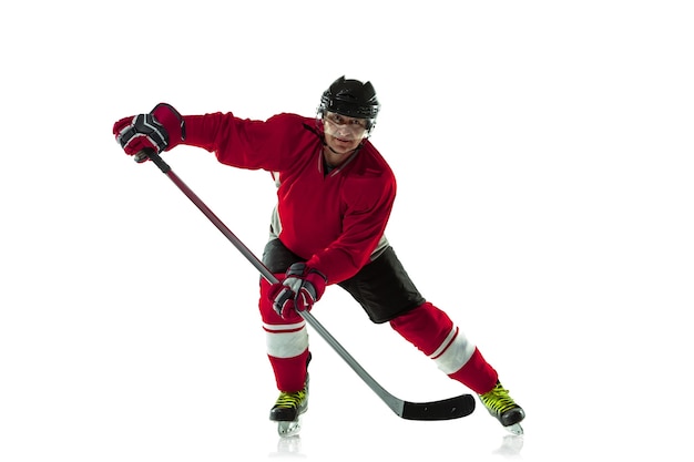 Jugador de hockey masculino con el palo en la cancha de hielo y fondo blanco.