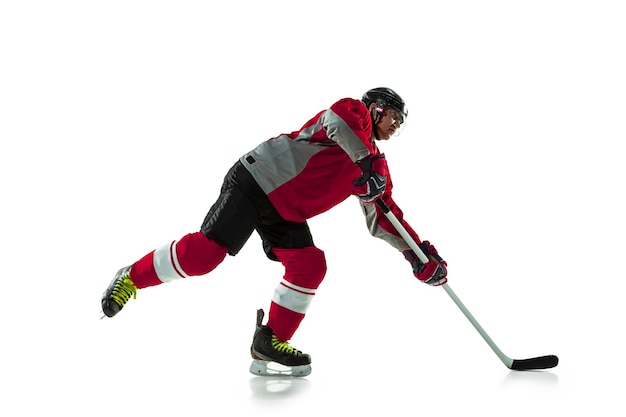 Foto gratuita jugador de hockey masculino con el palo en la cancha de hielo y pared blanca