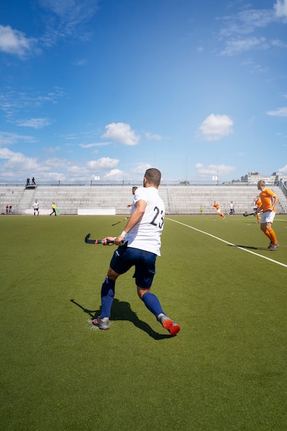 Foto gratuita jugador de hockey sobre césped entrenando y practicando el deporte sobre hierba