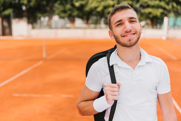 Foto gratuita jugador joven atlético de tenis posando