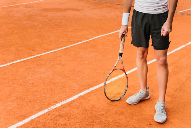 Jugador joven atlético de tenis posando