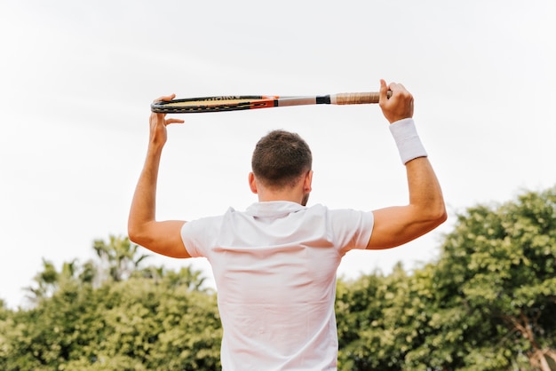 Foto gratuita jugador joven atlético de tenis posando