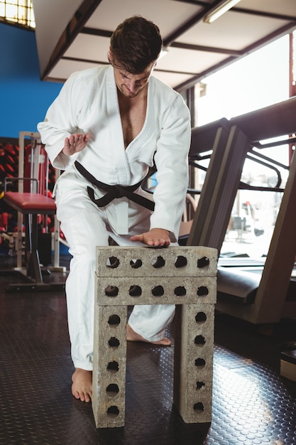 Jugador de karate rompiendo bloque de hormigón