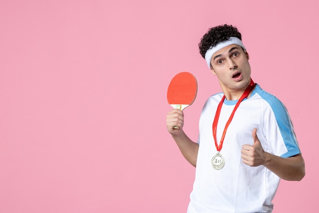 Jugador masculino de vista frontal con medalla sosteniendo raqueta pequeña