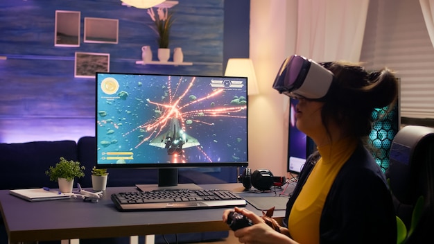 Jugador profesional con gafas vr sentado en una silla de juego jugando al juego de disparos espaciales en línea