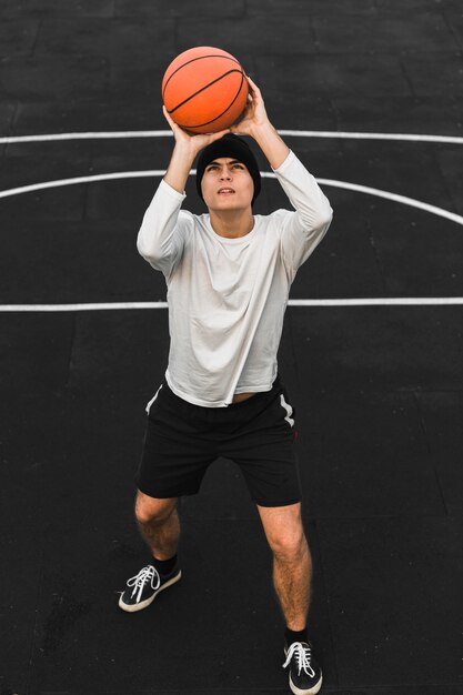 Jugador profesional lanzando baloncesto tiro completo