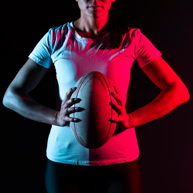 Jugador de rugby femenino atlético sosteniendo la bola