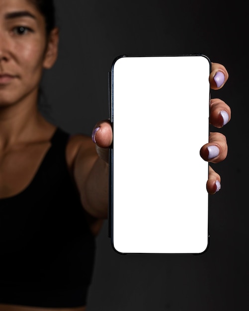 Jugador de rugby femenino Defocused con smartphone