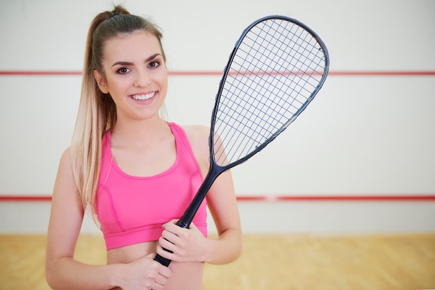 Jugador de squash femenino alegre con raqueta