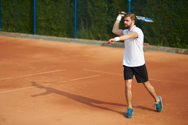 Jugador de tenis con raqueta en la cancha