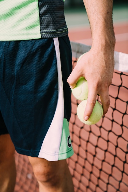 Jugador de tenis sujetando pelotas