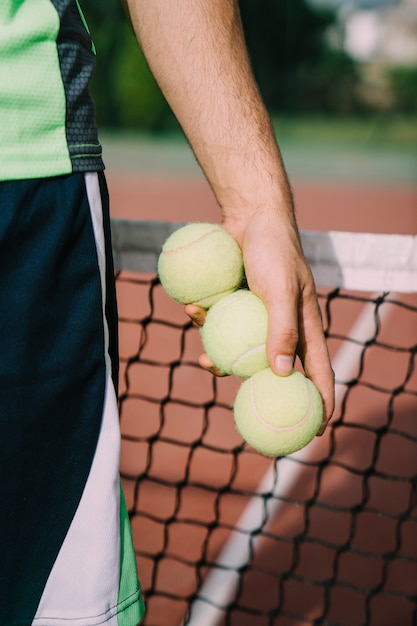 Foto gratuita jugador de tenis sujetando tres pelotas
