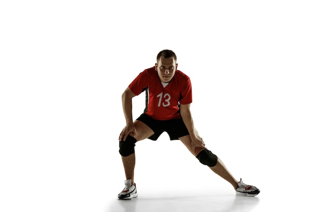 Jugador de voleibol caucásico joven placticing aislado sobre fondo blanco.