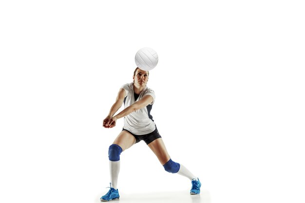 Jugador de voleibol femenino joven aislado sobre fondo blanco de estudio. Mujer en equipamiento deportivo y zapatos o zapatillas de deporte entrenando y practicando. Concepto de deporte, estilo de vida saludable, movimiento y movimiento.