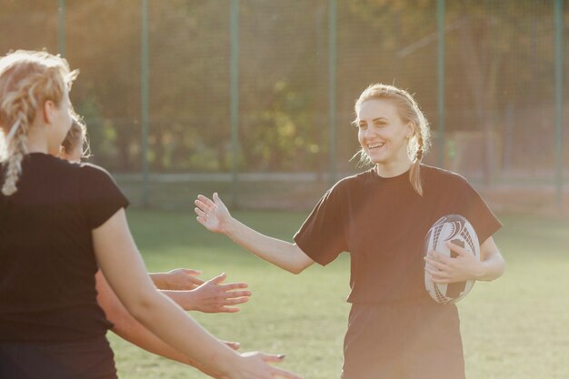 Jugadora de rugby saludando a sus compañeros de equipo