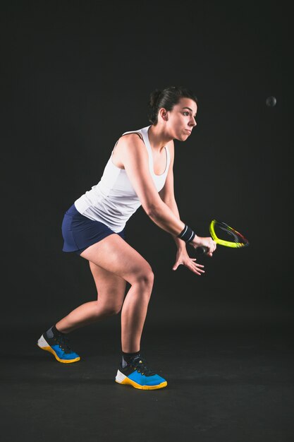 Jugadora de squash mirando la pelota atentamente