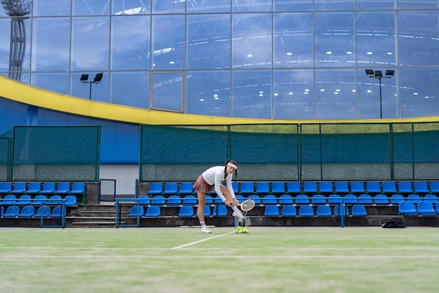 Jugadora de tenis sobre césped de corte verde