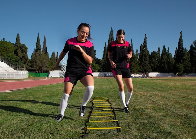 Foto gratuita jugadores de fútbol femenino de tiro completo en el campo